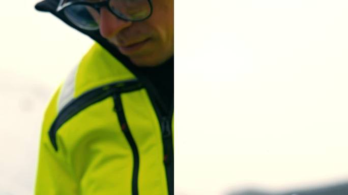 专注的中年白人工程师在太阳能农场使用智能手机。