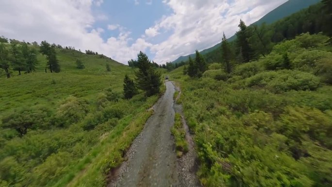 无人机飞越山地公路，拍摄越野车。