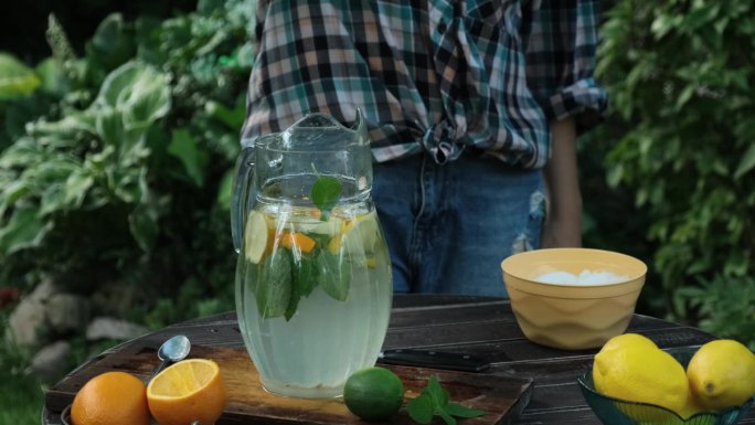 女人在户外喝清爽的夏季柠檬水。