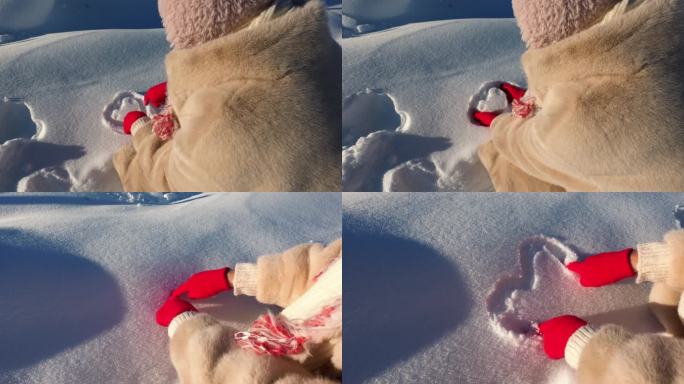 戴红手套的手在雪上画心形