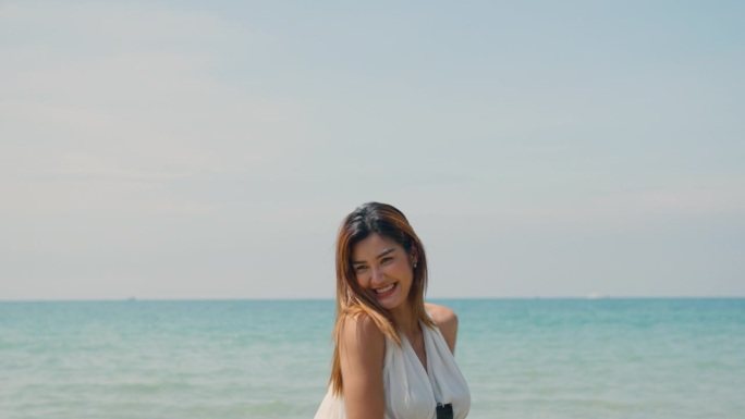 年轻女性在夏季假期中在海里玩耍，笑容满面，享受假期的快乐。