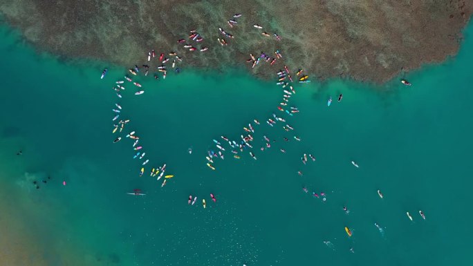 在度假期间，人们用冲浪板在海上形成圆圈的空中平移镜头-夏威夷瓦胡岛