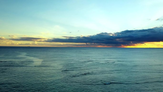 航拍的海景与地平线下多云的天空在日落，无人机飞在水上-瓦胡岛，夏威夷