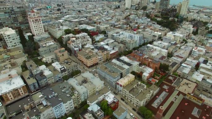 空中倾斜拍摄的建筑物在现代城市附近的大海对天空，无人机飞越城市景观-旧金山，加利福尼亚