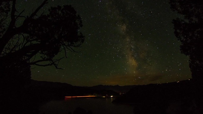 锁定时间延时长曝光车辆在河中山脉反对银河星空在夜晚-洛杉矶，加利福尼亚