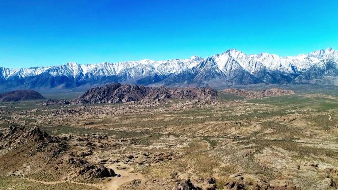 空中风景的雪山山脉反对晴朗的天空，无人机飞行在宁静的沙漠景观-大松树，加利福尼亚