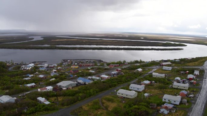 航拍的人类住区附近的海对天空，无人机向后飞越沿海房屋-白令海，阿拉斯加