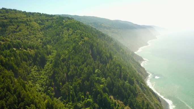 空中拍摄的风景山在晴朗的日子，无人机飞过美丽的海岸线-北加州，加利福尼亚州