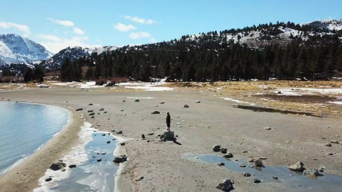 航拍:站在湖岸岩石上的人