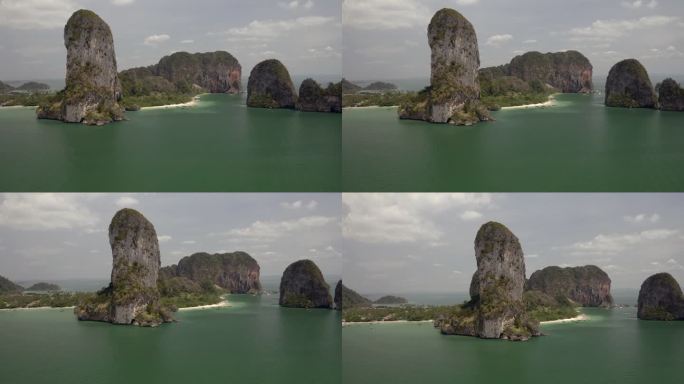 在一片朦胧的天空下，用小船和翠绿的海水在空中扫掠泰国海湾中高耸的岩石-普吉岛，泰国