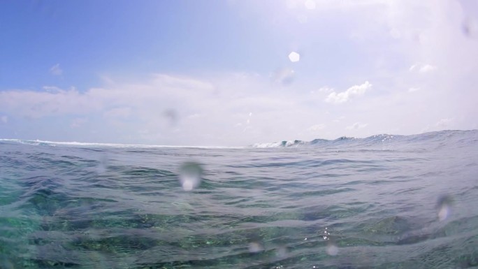 在阳光明媚的日子里，美丽的海浪在海上对着天空的慢镜头-南马累环礁，马尔代夫