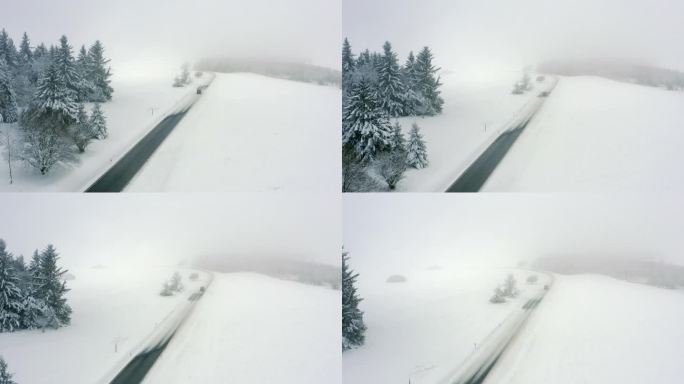 空中扫荡一个雾蒙蒙的冬天的道路，有高耸的松树，雪，和一辆过路的汽车- Oberweissenbrun