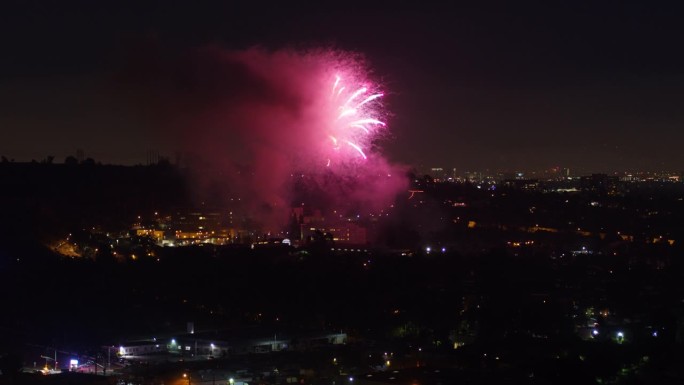 空中向前拍摄的美丽的粉红色烟花在照亮的城市-洛杉矶，加利福尼亚