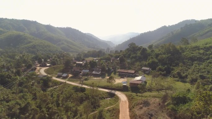 在阳光明媚的日子里，无人机在山谷里的树木和植物上空飞行，老挝湄公河