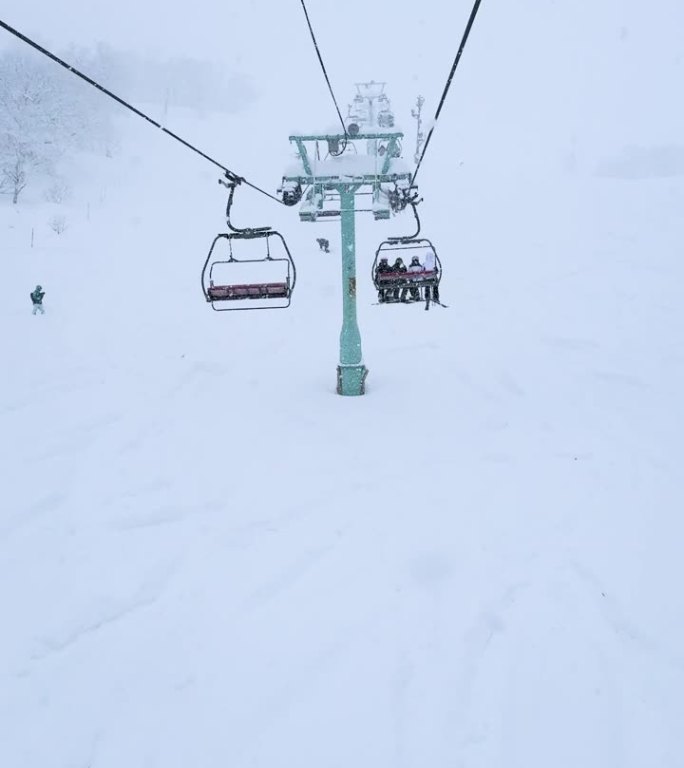 POV，空中视角：滑雪者和单板滑雪者在二世古的粉雪坡道上划出优美的弧线。