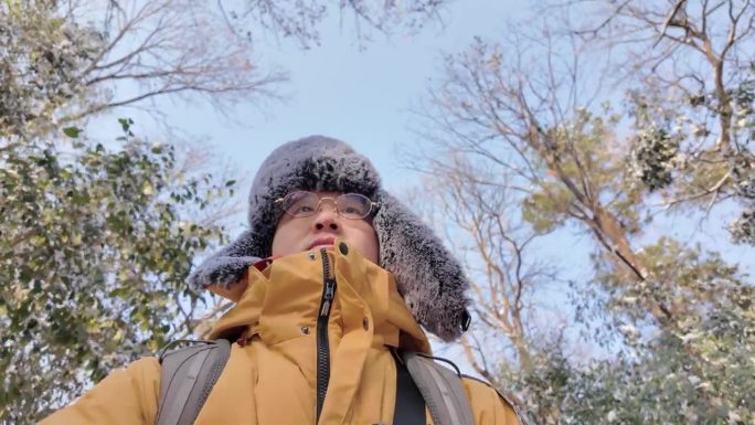 An Asian man walking in the forest