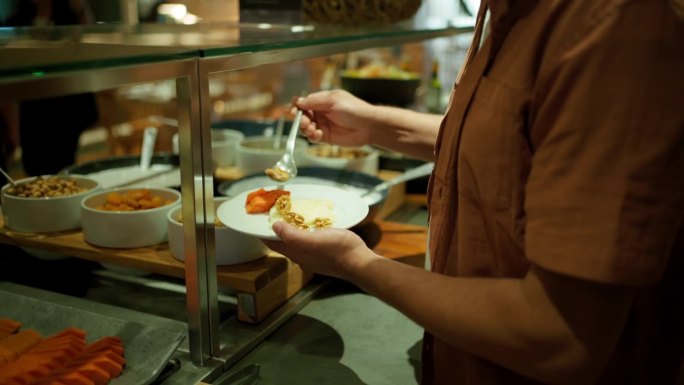 在酒店自助餐厅自助取餐的男子