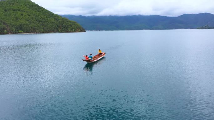 泸沽湖群山环绕湖面泛舟划船平静湖面航拍