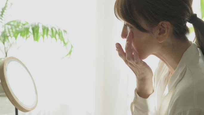对着镜子涂眼霜的女人