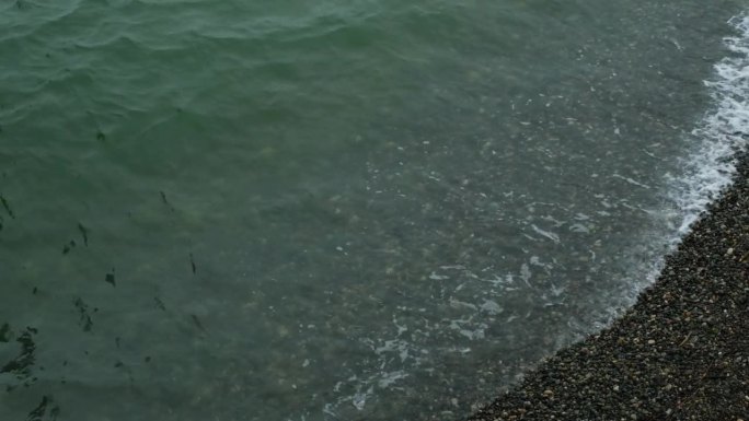 暴雨来临前，汹涌的海水和海浪拍打着海岸。波浪拍打着海岸，溅起水花。海的看法。水边，海岸线。海洋运输的