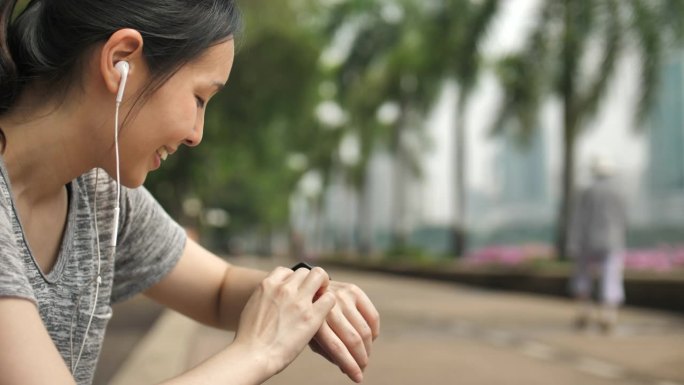 运动的亚洲女性使用智能手表