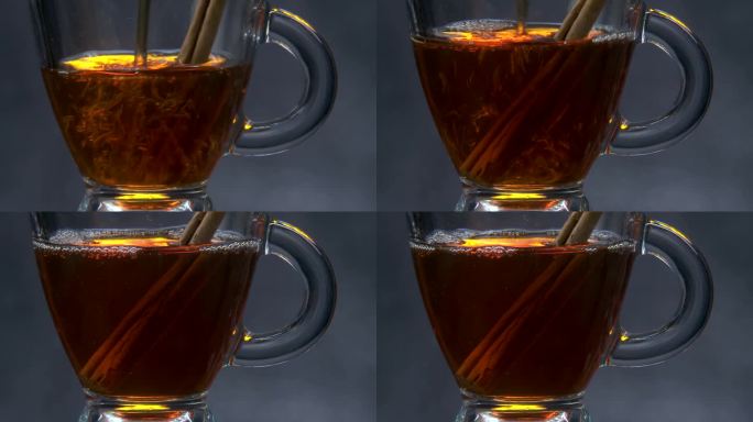 茶倒在肉桂香料棒玻璃茶杯近距离