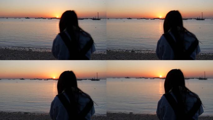 海边一名女子在夕阳下孤独的等待