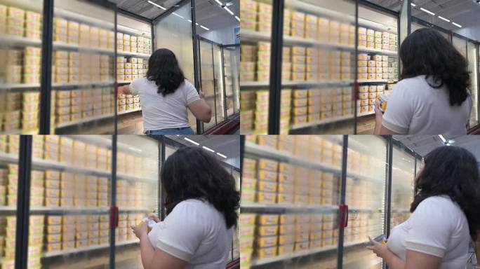 女人在冷冻和乳制品区推着购物车，挑选商品并进行购买。