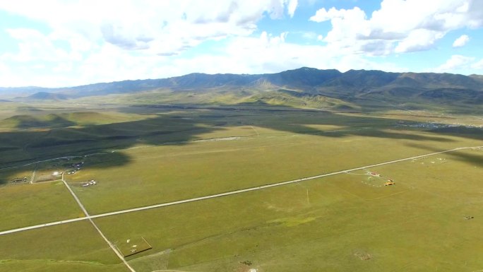 航拍的道路延伸到遥远的地平线上的草原，中国甘肃。