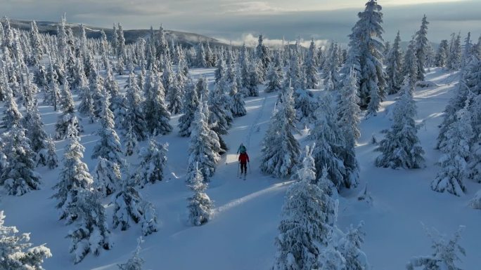 冬季山脉上，穿着雪鞋的滑雪旅行男女的航拍视角。