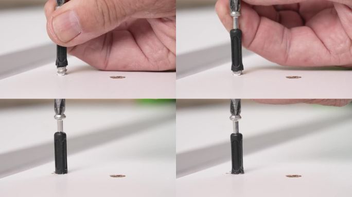 在家安装橱柜家具部件，特写镜头展示男性手部拧螺丝。