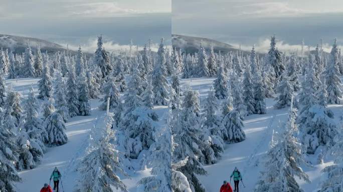 冬季山脉上，穿着雪鞋的滑雪旅行男女的航拍视角。