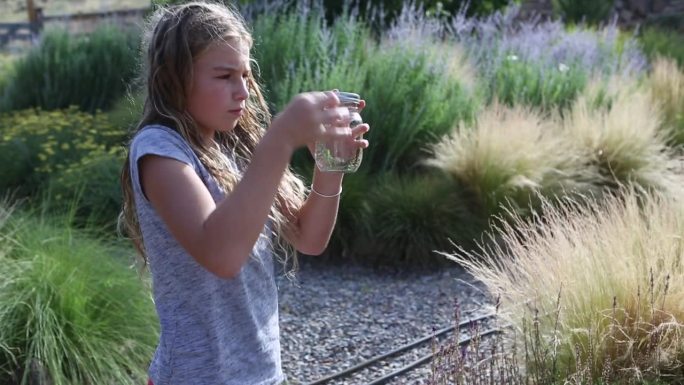 女孩在花园里捉蚱蜢