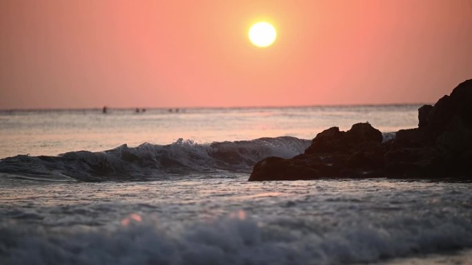 夕阳下海浪拍打岩石