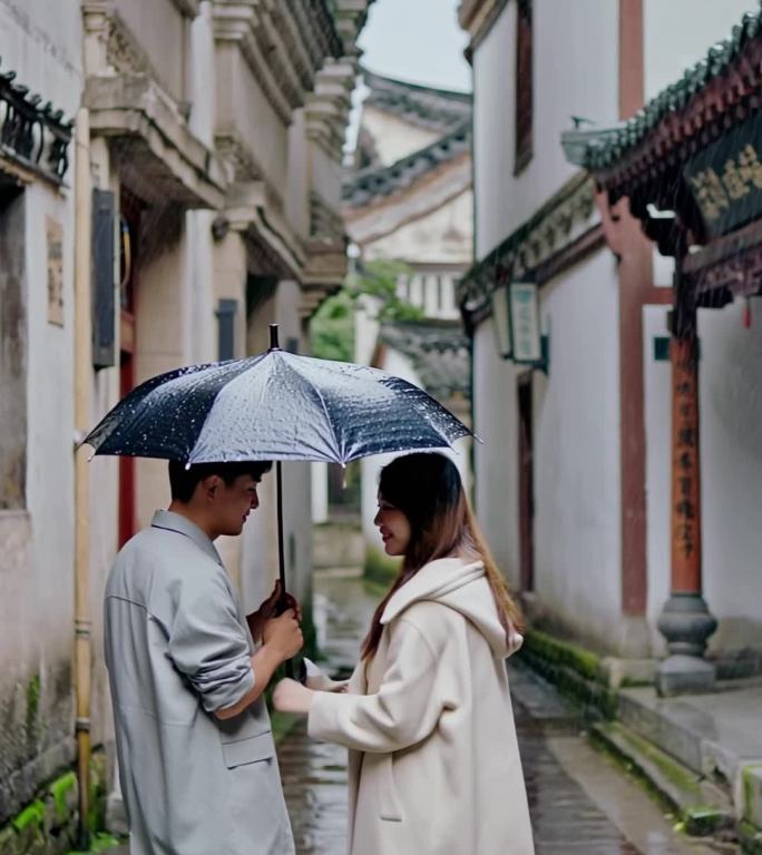 水乡雨巷青年情侣撑雨伞行走在古镇老街上