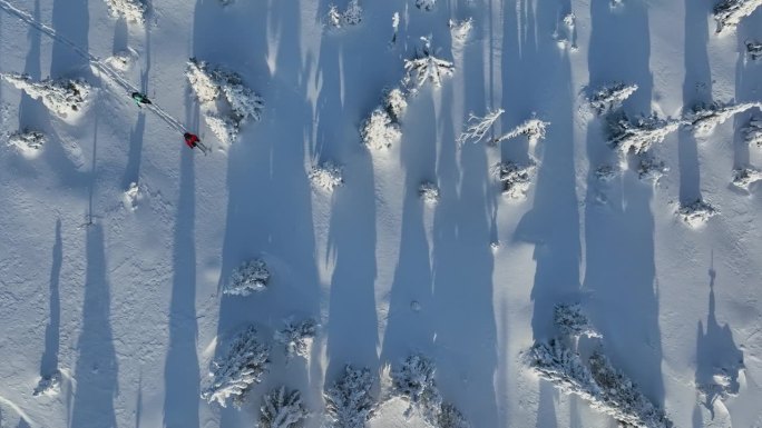冬季山脉上，穿着雪鞋的滑雪旅行男女的航拍视角。