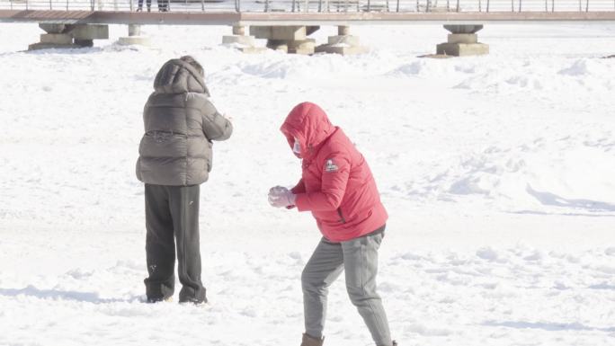雪地中亲子打雪仗互动玩耍