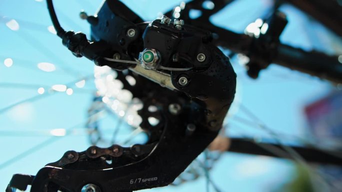在无接触洗车后清洗自行车。硬尾山地车在自助洗车后冲洗。特写湿润的变速器、后拨、导轮和上滑轮。