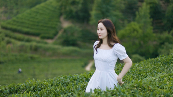 年轻女子在茶山漫步品茶