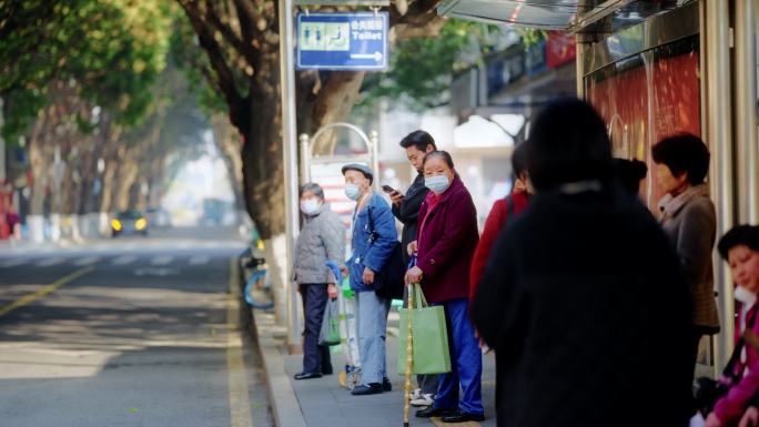 戴口罩的市民在公交站等车