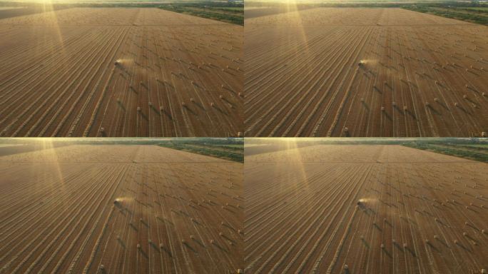 收割后的田野上，拖拉机牵引的打包机在空中俯瞰收集稻草。