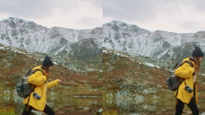 秋天，女性徒步旅行者在山湖附近穿越溪流。