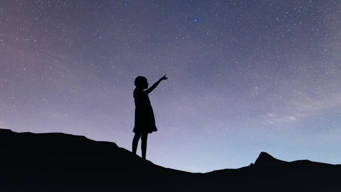 夜晚孩子站在山顶上仰望星空
