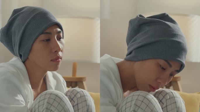绝望的年轻亚洲女性因癌症而生病，坐在家中客厅的沙发上。医疗保健概念。