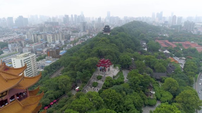 武汉，中国 - 2025年1月19日：航拍镜头展示了令人印象深刻的塔楼和环绕武汉的绿色山丘。