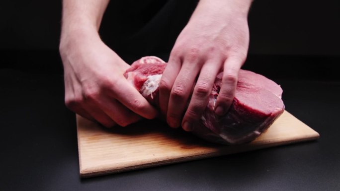 一位专业按摩师正在按摩一块牛肉。在烤制之前对牛排进行揉捏和按摩。展示按摩对肌肉的效果。