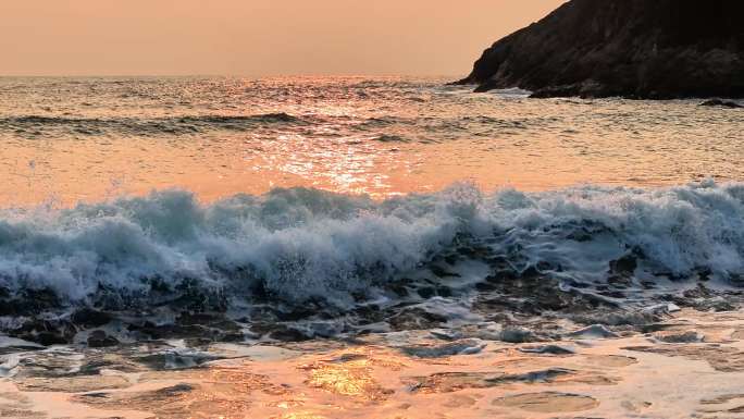 金色夕阳下的海景 海浪拍打海岸礁石