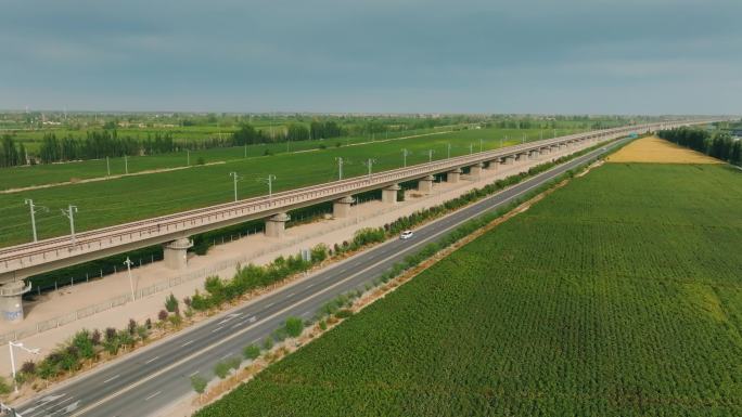 新疆哈密绿色田野上的高铁飞驰