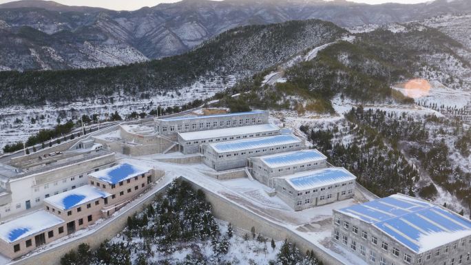 冬季雪山下的建筑群村落风光鸟瞰航拍