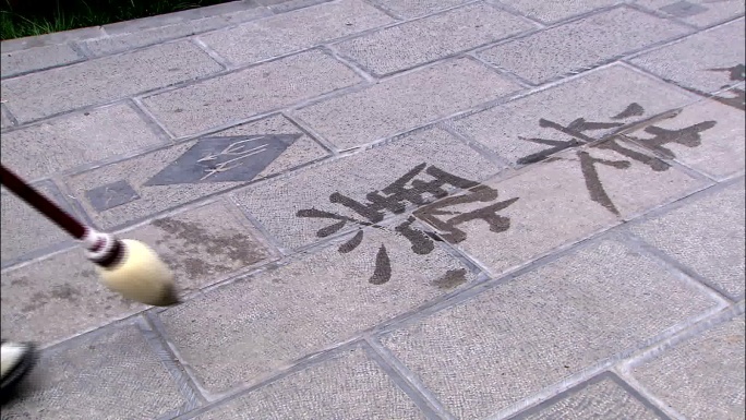 公园里老人地上写书法练字